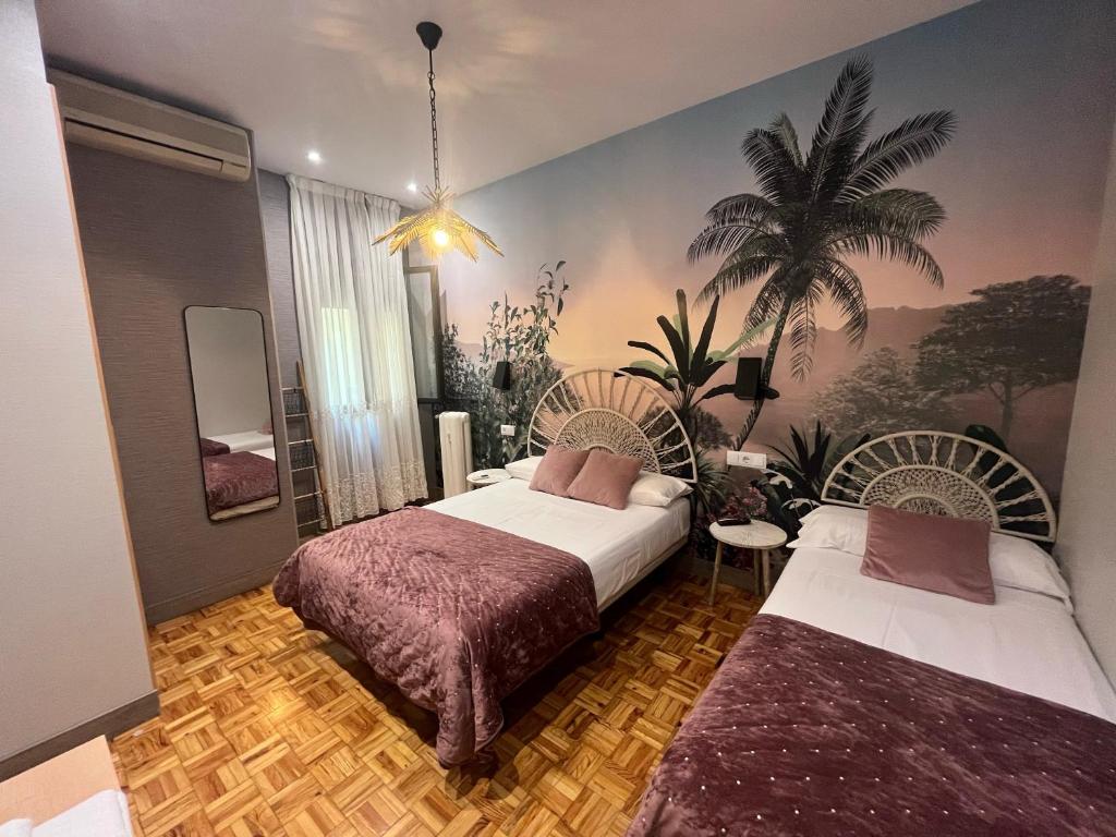 1 dormitorio con 2 camas y un mural de palmeras en Hostal Avenida, en Madrid