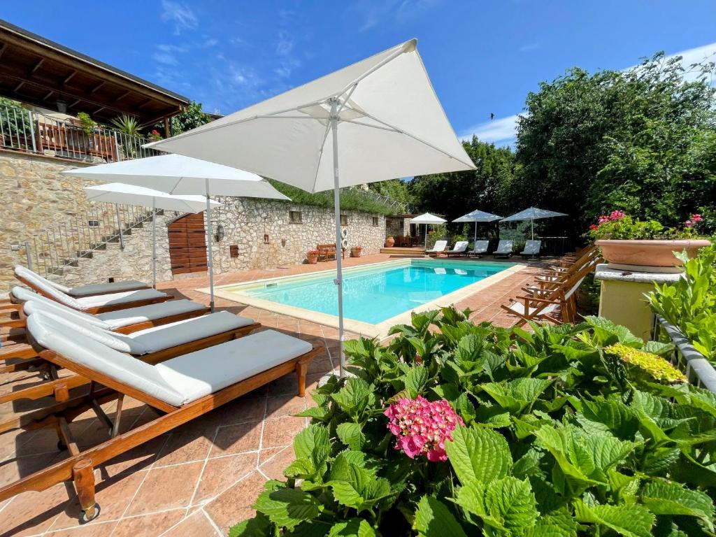 einen Pool mit Liegestühlen und einem Sonnenschirm in der Unterkunft Spoleto Splashcasa Piscinaslps 4wifidishwasher - very pretty setting nr pool in Strettura