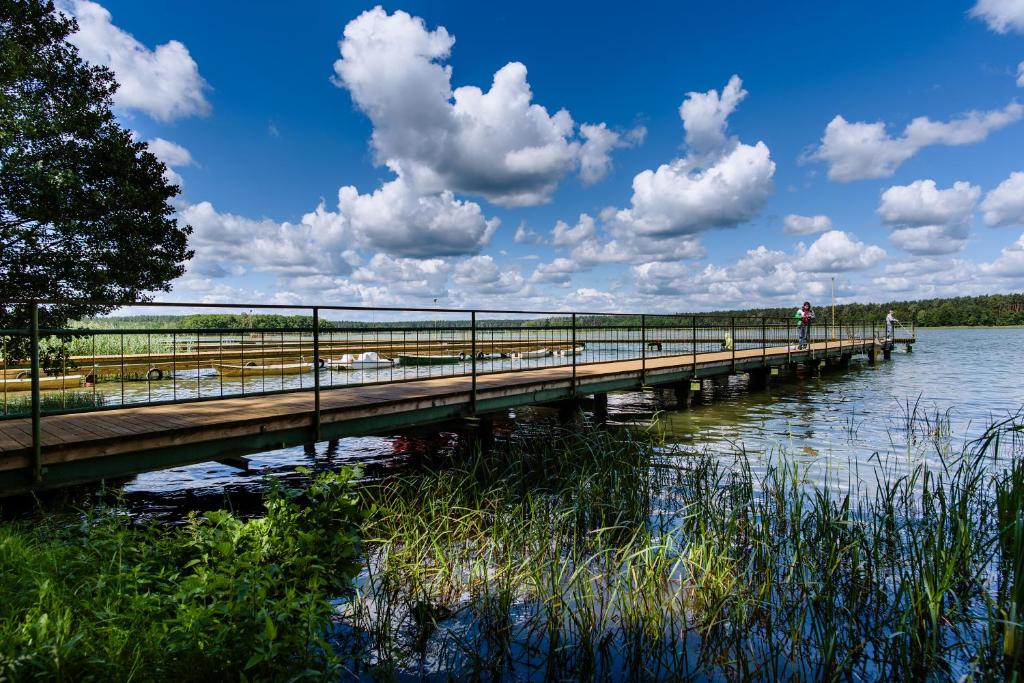 a wooden bridge over a body of water at Wiartel Osrodek Wypoczynkowy in Pisz