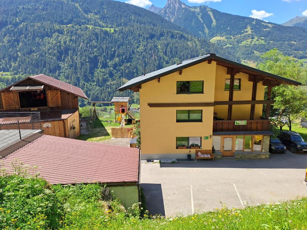 ein Haus in den Bergen mit Parkplatz in der Unterkunft Alpenbauernhaus Konzett in Schruns-Tschagguns
