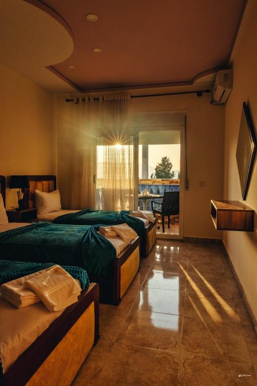 Una habitación de hotel con tres camas y balcón. en CHEZ AZIZ Holiday apartment, en Chefchaouen