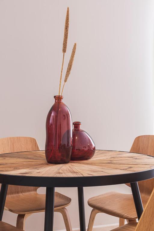 two vases sitting on a wooden table with chairs at Apartamentos Martalia Áticos Deluxe in Ronda