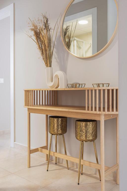 a dressing table with a mirror and two stools at Apartamentos Martalia Áticos Deluxe in Ronda