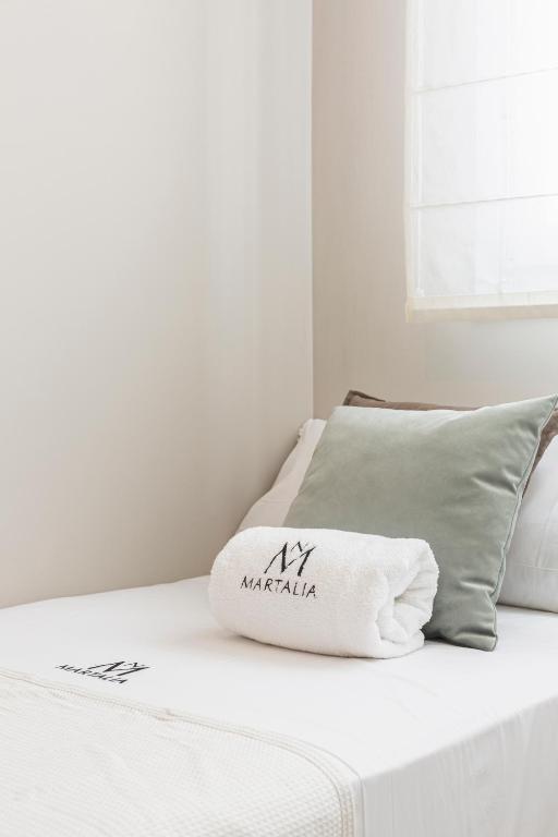 a white bed with a pillow on top of it at Apartamentos Martalia Áticos Deluxe in Ronda