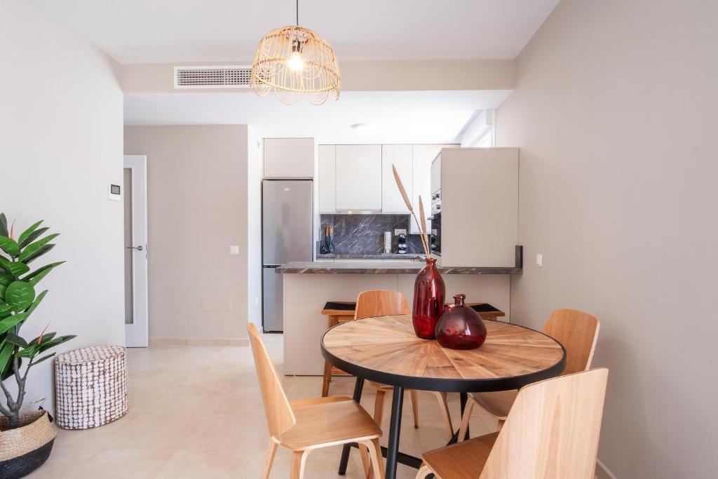 a kitchen and dining room with a table and chairs at Apartamentos Martalia Áticos Deluxe in Ronda