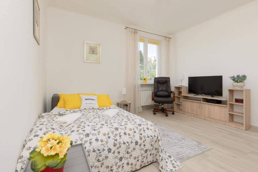 a white bedroom with a bed and a tv at Racławicka Cozy Studio Apartment by Renters in Warsaw