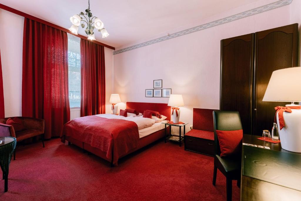 a bedroom with a bed and a red carpet at Hotel Der Schwan in Einbeck