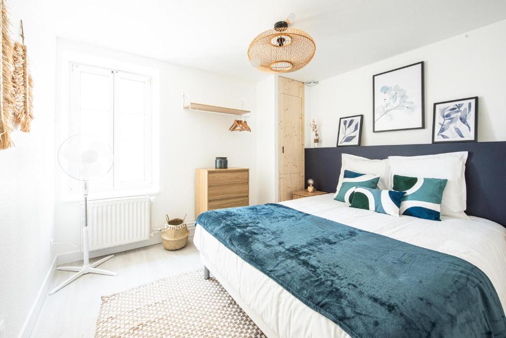 - une chambre avec un lit bleu et blanc et une fenêtre dans l'établissement Les Coulisses - Duplex au centre - Parking privé, à Colmar
