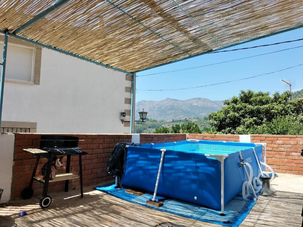 eine Terrasse mit blauer Decke und einem Tisch in der Unterkunft La casa de tío Vidal in Pedro Bernardo