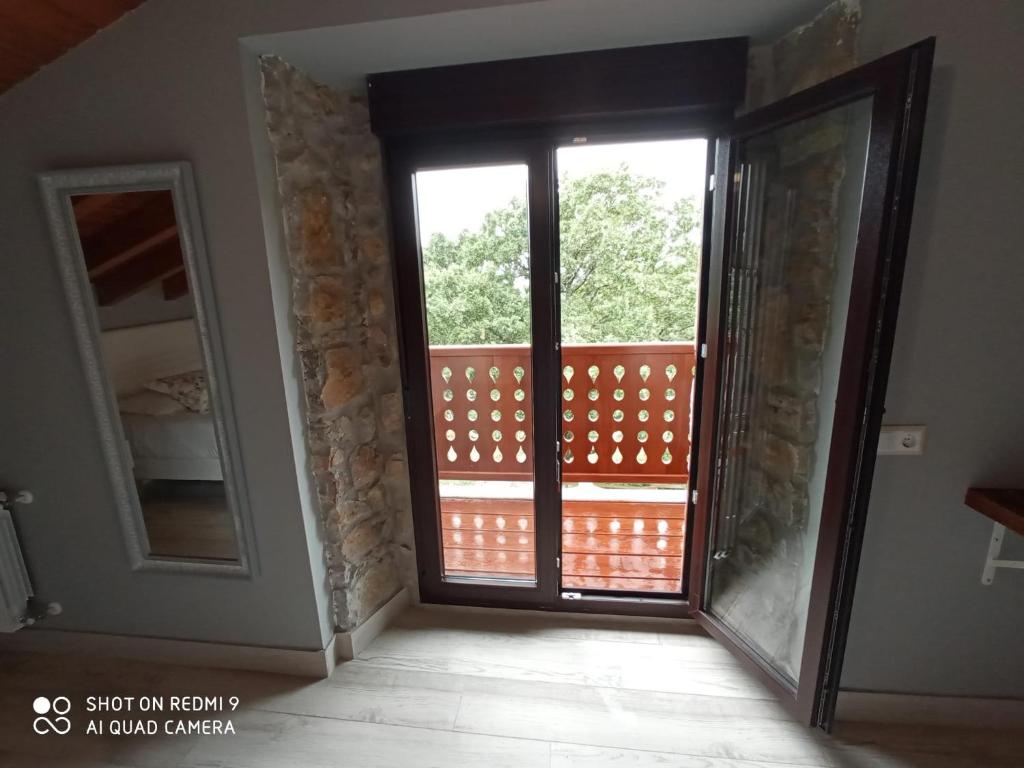a room with a sliding glass door with a balcony at Posada las Albarcas in La Cavada