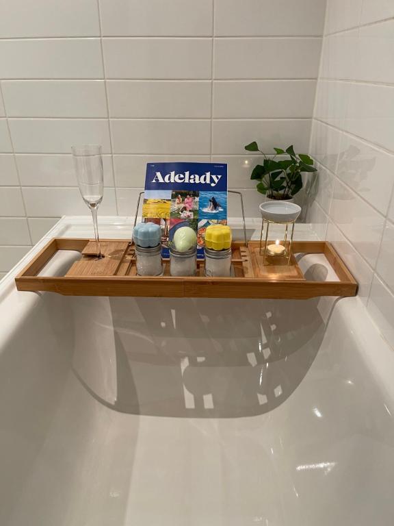 a wooden shelf with some candles and a wine glass at Glenelg resort style beachside apartment in Glenelg
