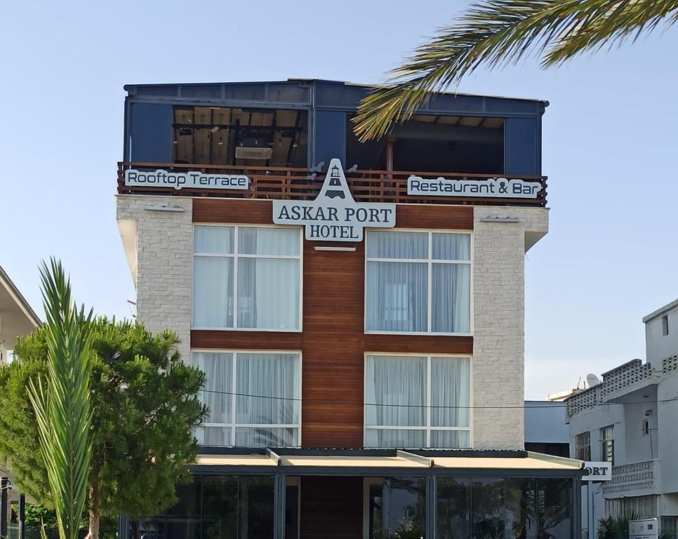 a apartment building with a sign for aagent point hotel at ASKAR PORT OTEL in Tasucu