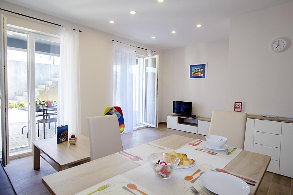 een keuken en een woonkamer met een tafel en stoelen bij Apartments Ragusa Palace 1 Djardin in Dubrovnik