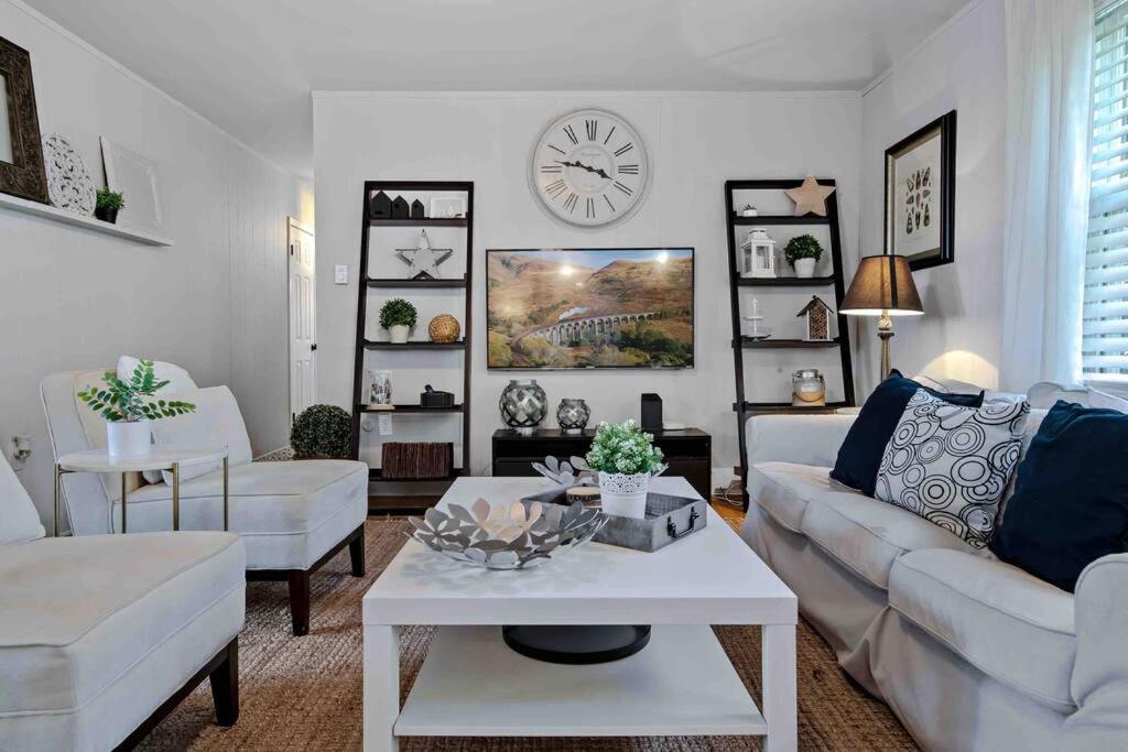 sala de estar con muebles blancos y reloj en la pared en Beautiful Renovated Beach Condo in Center of OC, en Ocean City