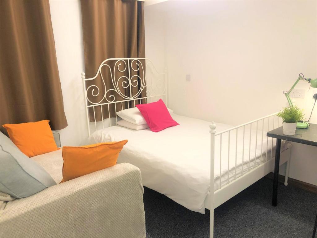 a bedroom with a white bed with colorful pillows at Breeze Homstay in Tile Hill