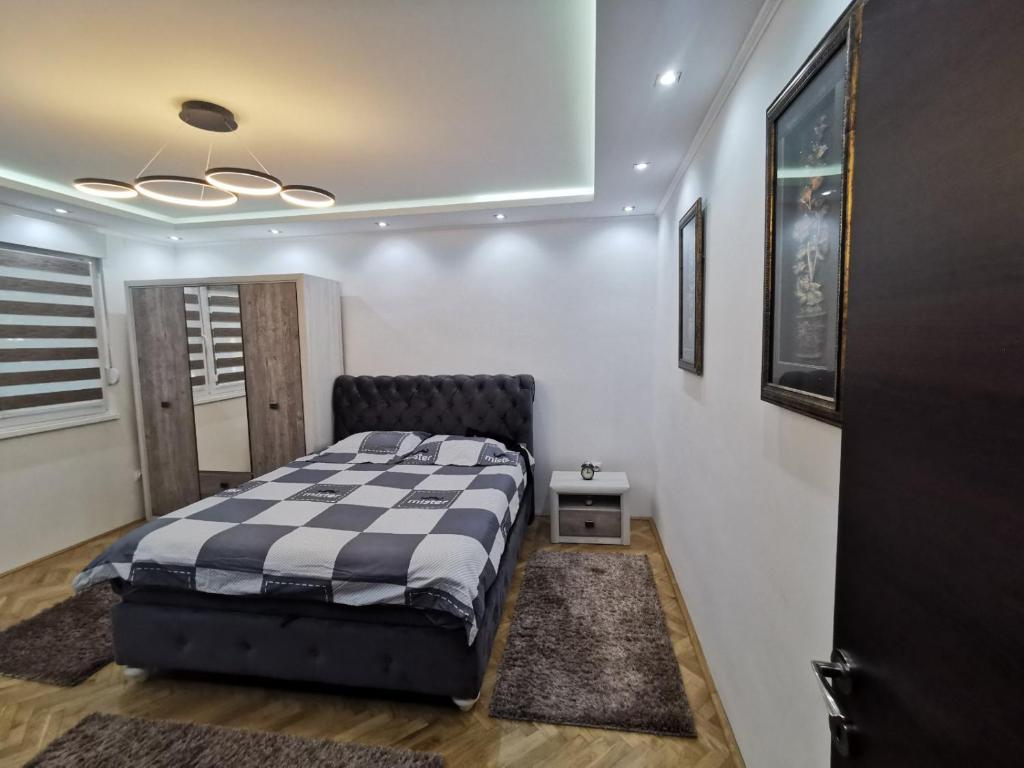 1 dormitorio con 1 cama en una habitación con puerta en Apartman Cipi2, en Sombor
