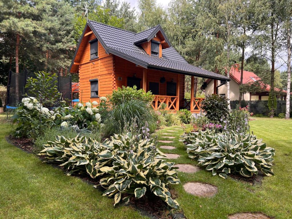 una casa de madera con un jardín delante de ella en Otulina Gulczewo en Wyszków