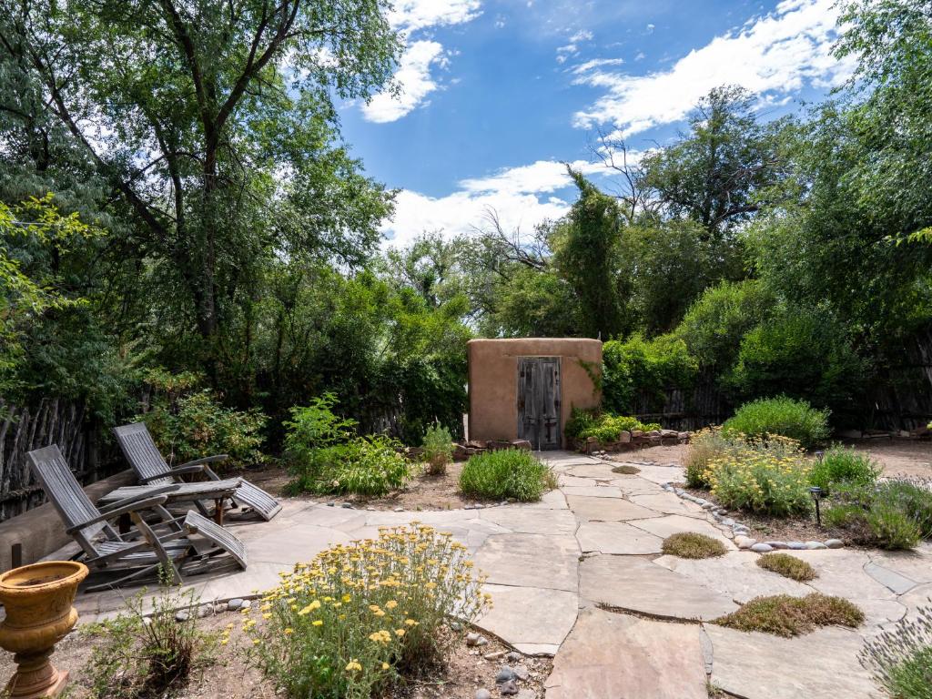 un jardín con 2 sillas y un patio de piedra. en El Nido Lane Tesuque, 1 Bedroom, Sleeps 2, Private Yard, WiFi, Washer/Dryer en Santa Fe
