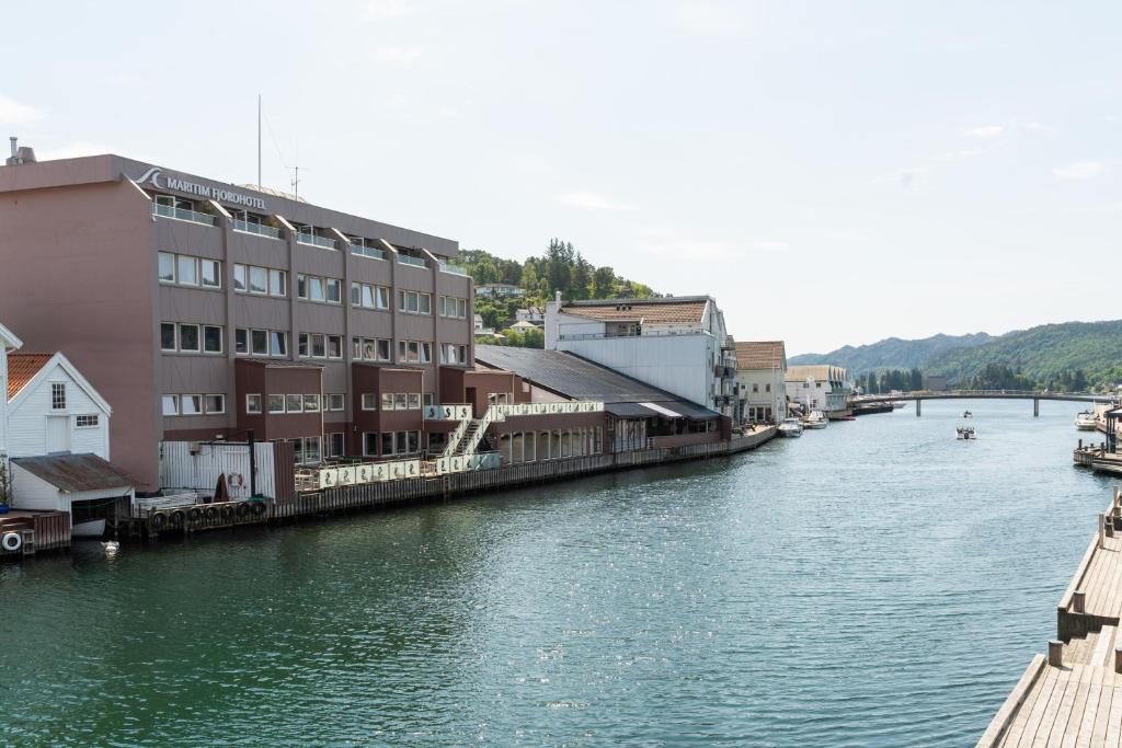 a view of a river with buildings on the side at Maritim Fjordhotel in Flekkefjord