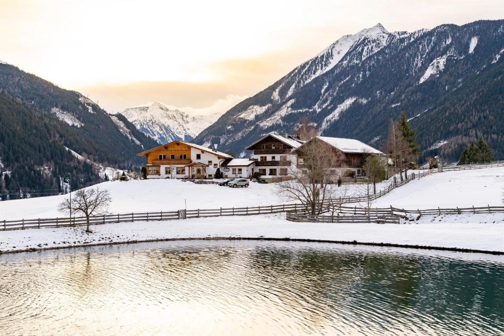 a house in the snow next to a river at Pension Braunhofer in Schladming