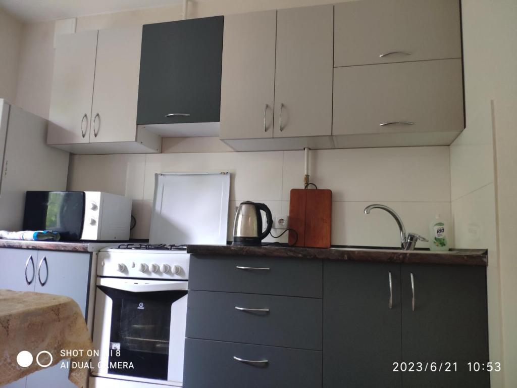 a kitchen with white cabinets and a stove top oven at Квартира на Агнии Барто in Dnipro