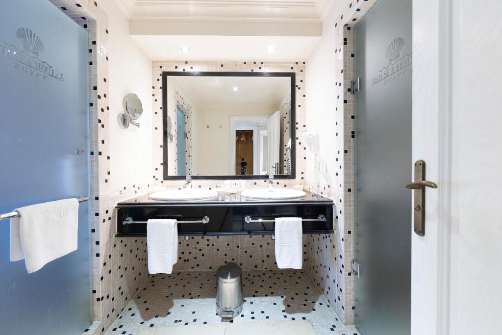 The Makadi Spa Hotel - Couples Only 18 Years Plus في الغردقة: حمام به مغسلتين ومرآة كبيرة