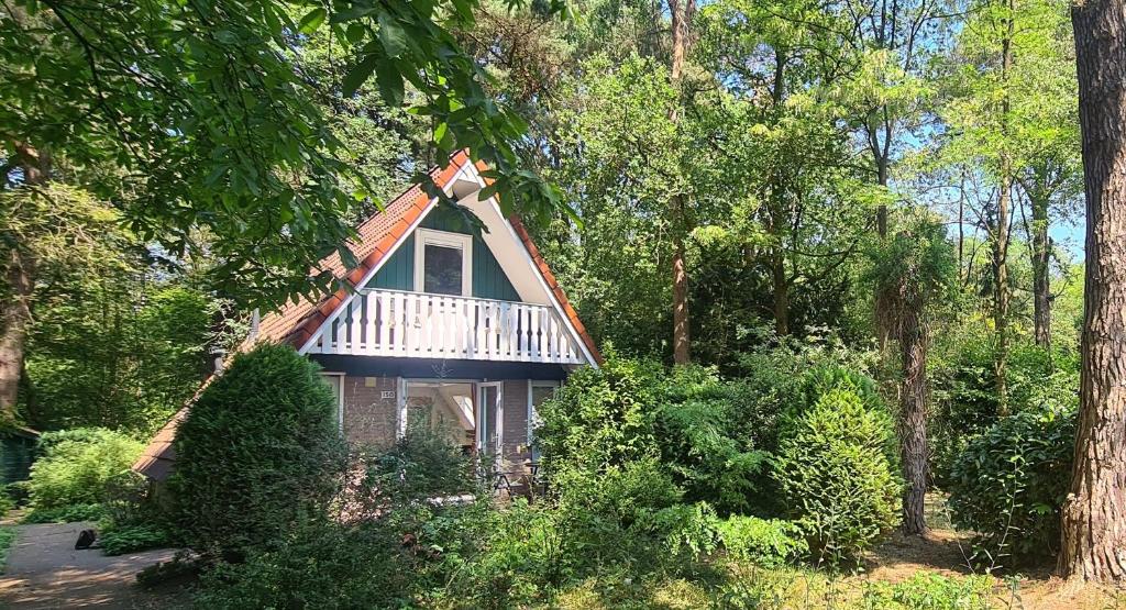 a small house with a gambrel roof in the woods at Bosvilla in Harfsen