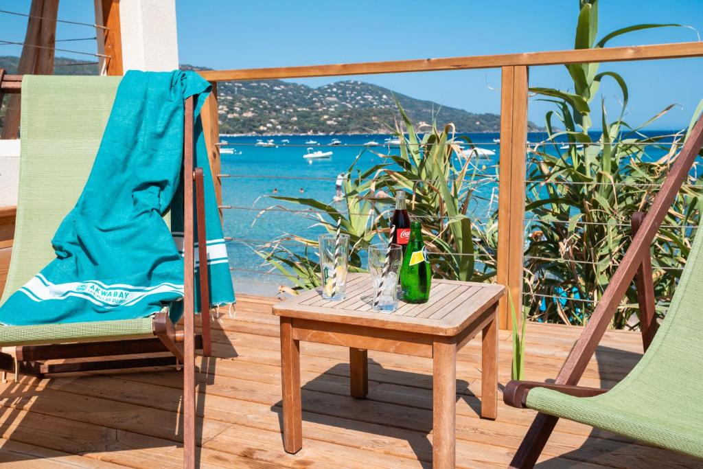 a patio with two chairs and a table with a bottle of champagne at Akwabay - Les Villas du Cap in Le Lavandou