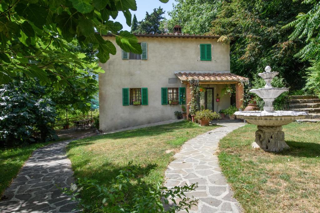 a house with a fountain in front of a yard at Villa Feraldi in Scopeti