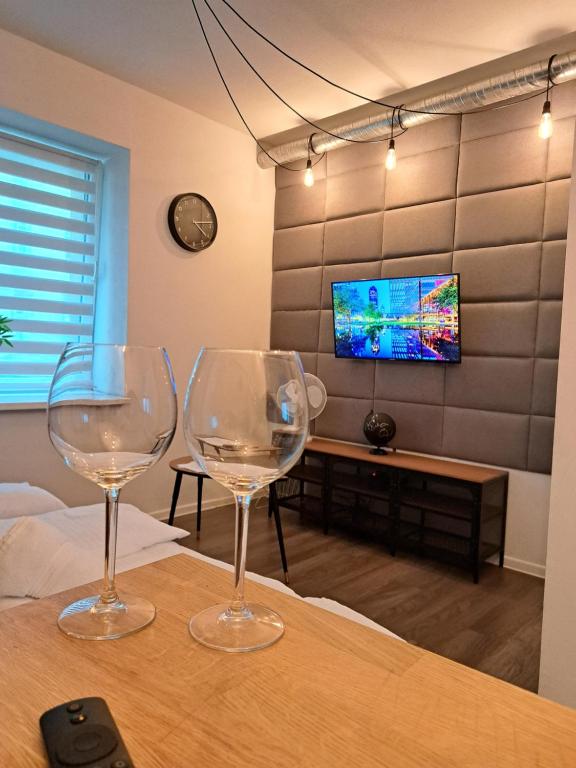 2 verres à vin assis sur une table dans une pièce dans l'établissement Apartamenty LENA 1, à Racibórz