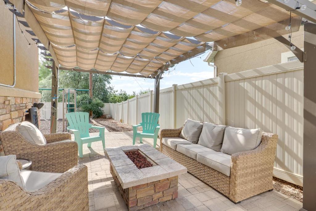 a patio with a couch and chairs under a pergola at Spacious Utah Retreat with Deck, Grill and Fire Pit! in Provo