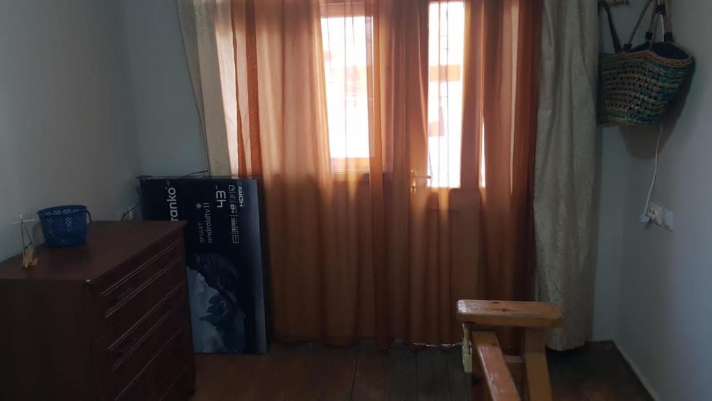 a room with a window with an orange curtain at Eka's Vacation House in Batumi