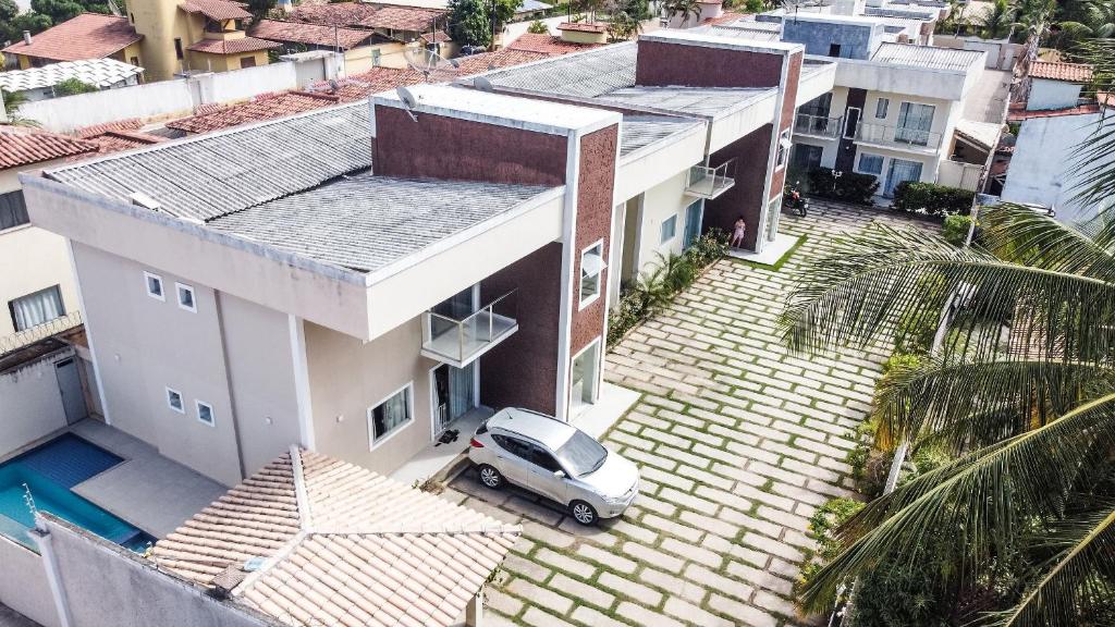 una vista aérea de una casa con un coche en la entrada en Apto Taperapuan 2 quartos com piscina perto praia, en Porto Seguro