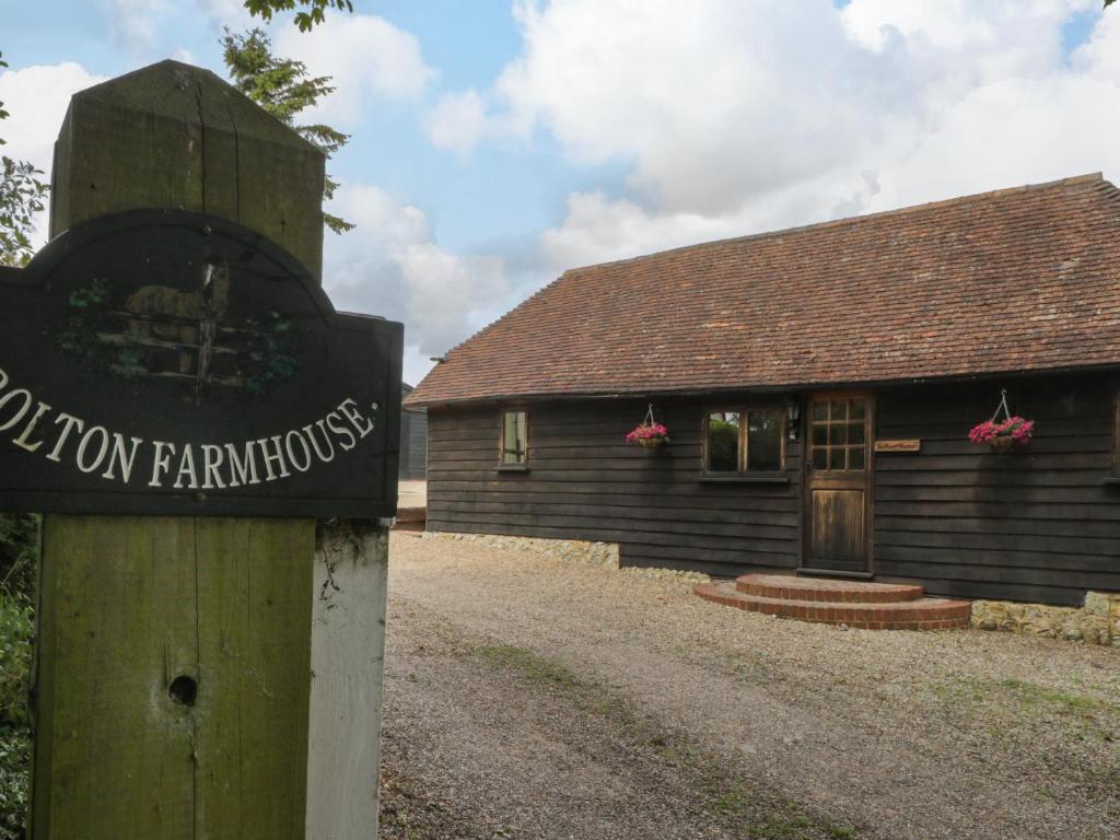 a sign in front of a wooden building at Bolton Barn in Lenham