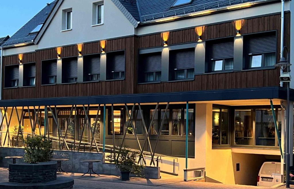 un edificio con ventanas y una mesa frente a él en Hochwald Lodge en Morbach