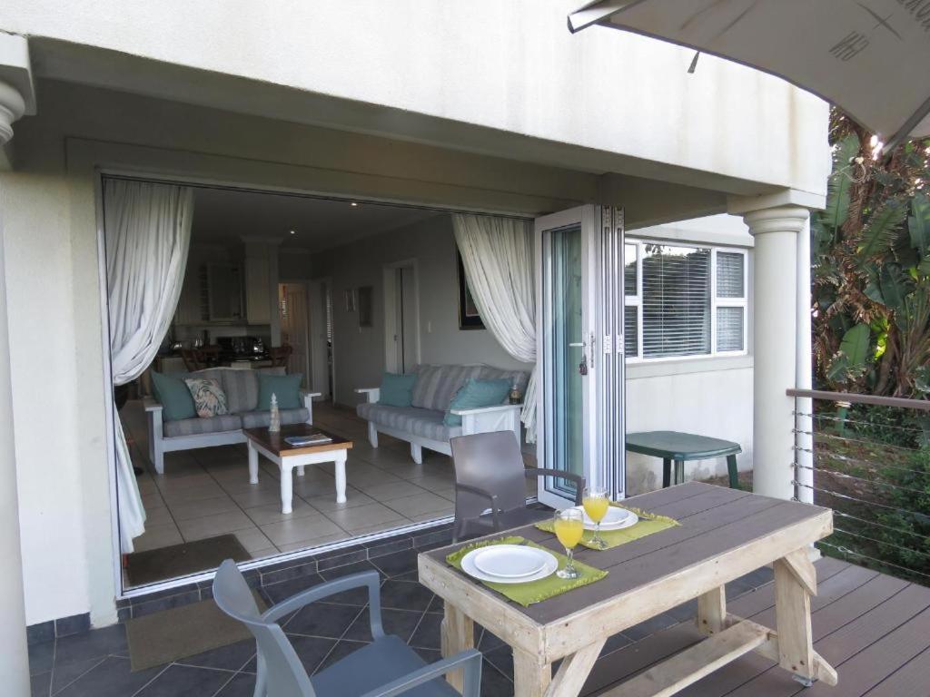a patio with a table and chairs on a deck at Mangrove Beach Estate - 3 Mtwalume in Port Shepstone