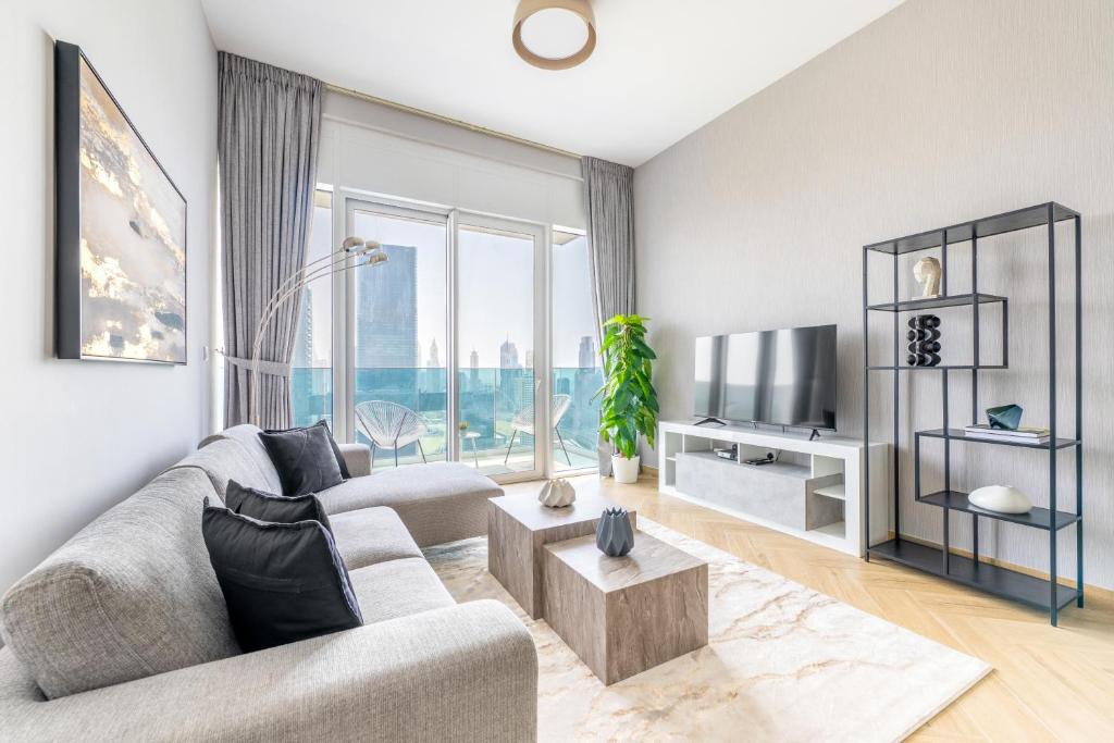 a living room with a couch and a tv at Ultra Luxury Wasl 1 Residences Zabeel Park in Dubai