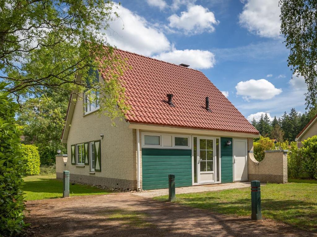 a small house with a green garage at Nice holiday home in Hellendoorn with terrace in Hellendoorn