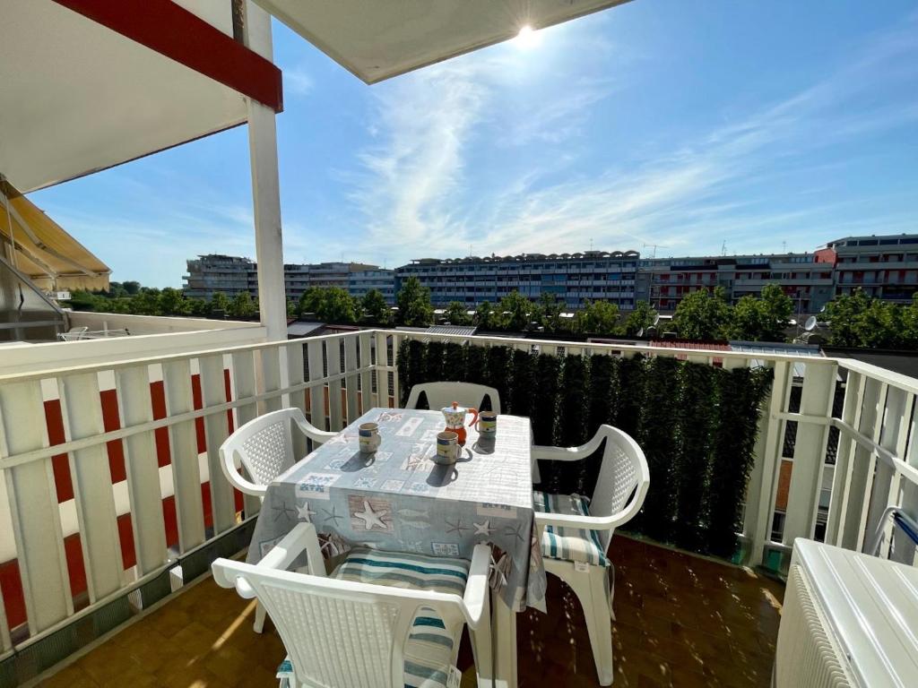 a table and chairs on a balcony with a view at Bright studio only 320mt from the sea in Porto Santa Margherita di Caorle