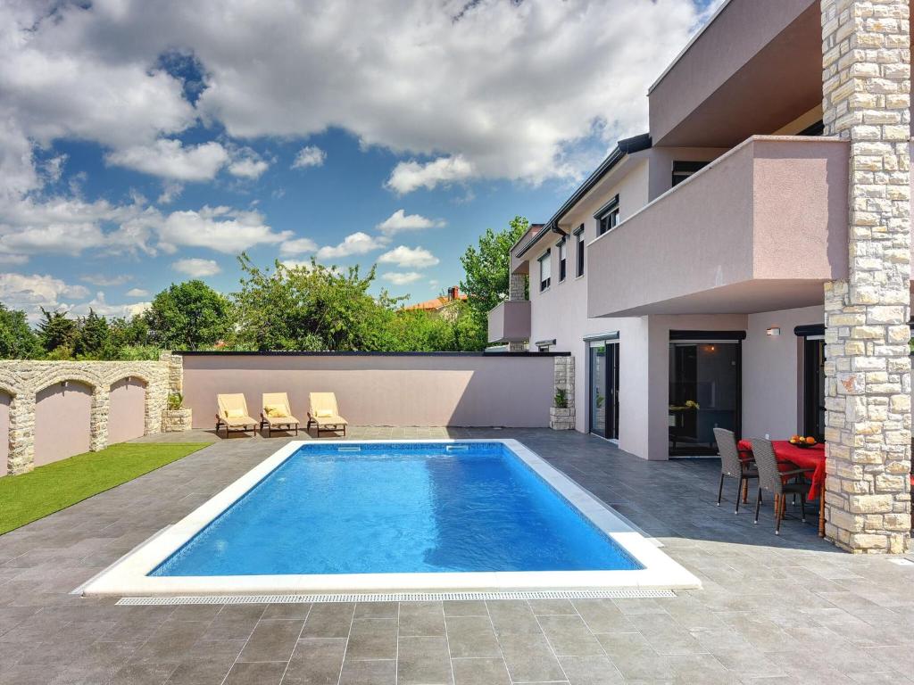 a swimming pool in the backyard of a house at Luxury villa with private pool, terrace and BBQ in Valbandon