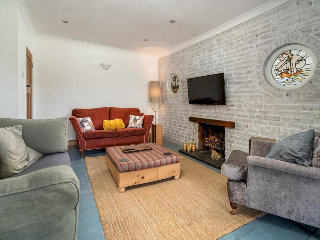 a living room with two couches and a brick wall at Pass the Keys Charming 3 bed house with parking and large garden in Radlett