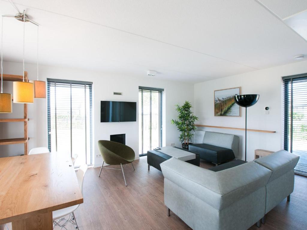 a living room with a couch and a table at Modern design lodge with combi microwave, in national park in Tholen