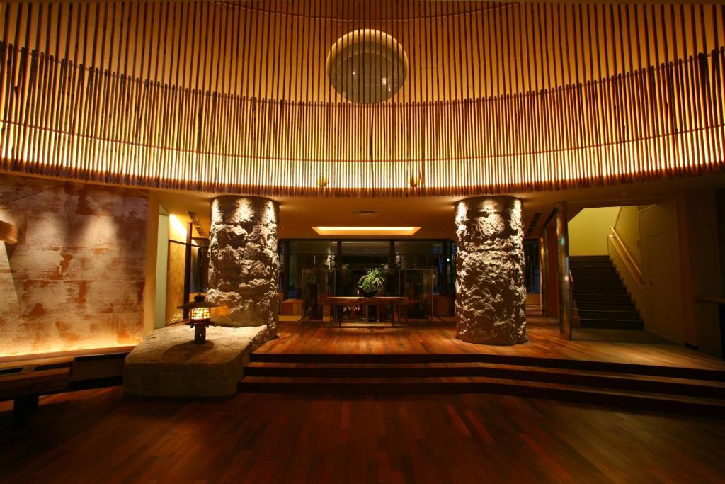 a lobby with two columns and a table in a building at Suizantei Club Jozankei-Adults Only in Jozankei