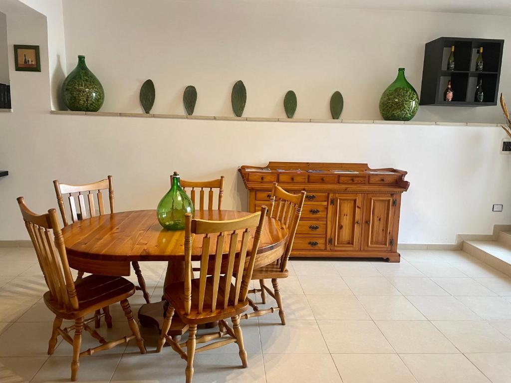 uma sala de jantar com mesa, cadeiras e vasos em AurEdo Apartment em Muro Leccese