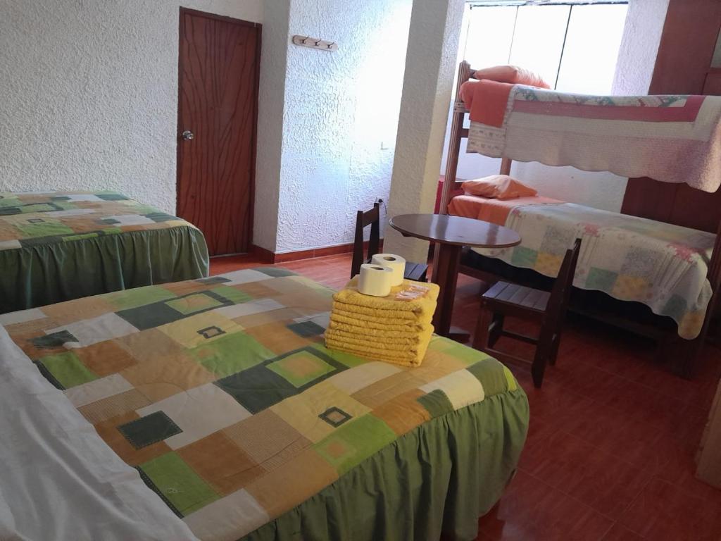 巴蘭卡的住宿－HOTEL CHORRILLOS BEACH，一间设有两张床和一张桌子及椅子的房间