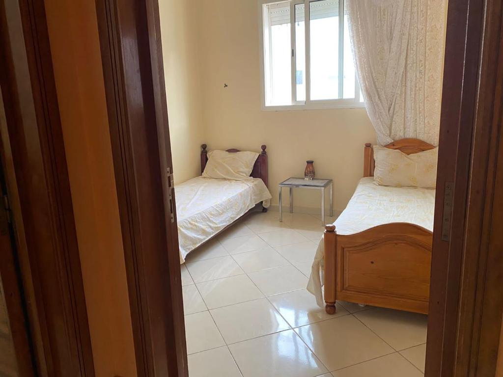 Cette chambre comprend 2 lits et une fenêtre. dans l'établissement Appartement agadir, à Agadir