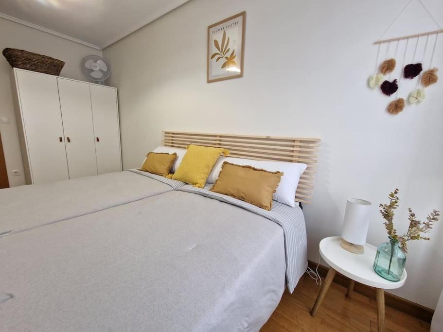 a white bedroom with a large bed and a table at Piso Al Norte in Treto