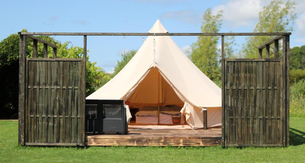 a tent with a door open in a field at Haramara Tipi in Vester-Skerninge