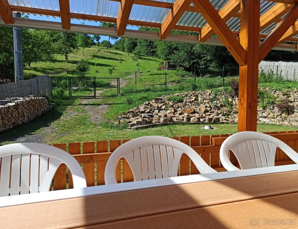 2 sillas blancas en un porche con vistas a un campo en Chalupa u Martina en Vápenice