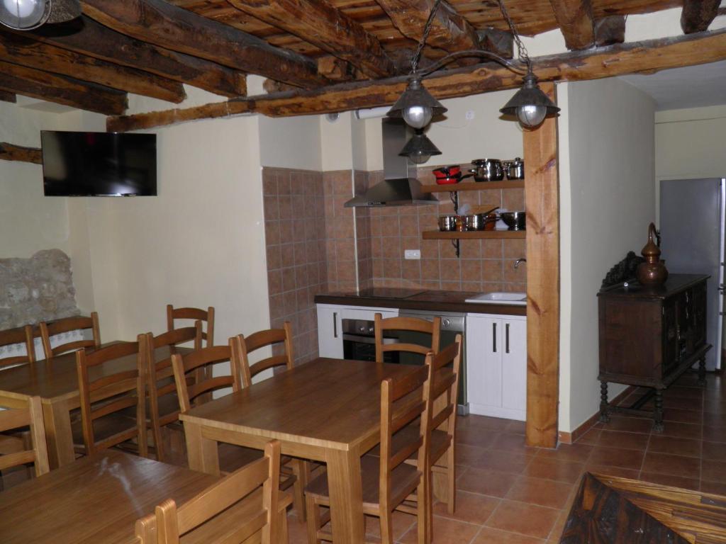 eine Küche und ein Esszimmer mit Holztischen und Stühlen in der Unterkunft Apartamentos Turísticos Peñafiel in Peñafiel